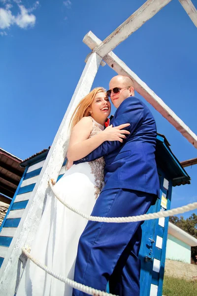 Pareja de boda alojada al lado de la casa blanca azul —  Fotos de Stock