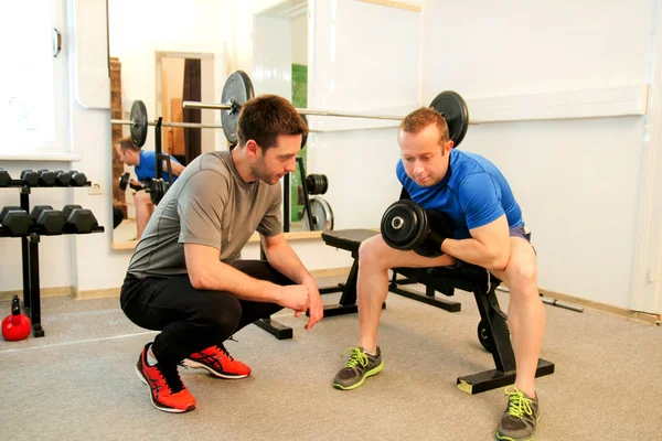 Young man working out biceps in a gym