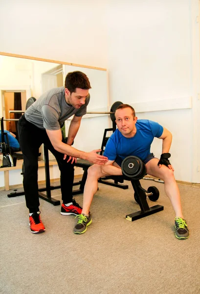 Young man working out biceps in a gym