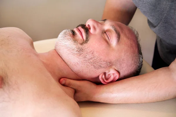 Man nemen van een massage-nek spieren op de massagetafel — Stockfoto