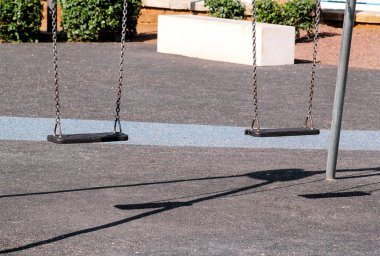 Şehir Parkı Swings. Yaz çocuk çocuklar oyun alanında boş zincir sallanır.