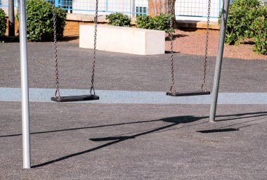Şehir Parkı Swings. Çocuklar oyun alanında boş zincir sallanır.