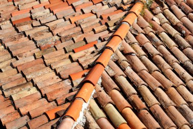 Bir ev bina, closeup çatısına kiremit parçası. Kırmızı kiremitli pişmiş çatı. Turuncu çatı kiremitleri, haritalar ve dokular. Doku döşeme. Arka plan ile çatı parçası. Satır çatı tuğla.