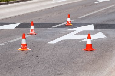Yol üzerinde çalışıyorum. Sokak işaretleri ve yol. Sinyal göndermeye yönelik yol işaretleri. Yol bakım, inşaat işareti ve trafik konileri yolda altında. Yol engeli alternatif yol gösteren beyaz ok ile.