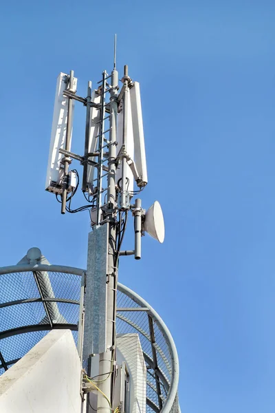 Telecommunication base stations network repeaters. The cellular communication aerial on a building. Communications cell phone telecommunication tower. Antenna tower and repeater. Modern technology.