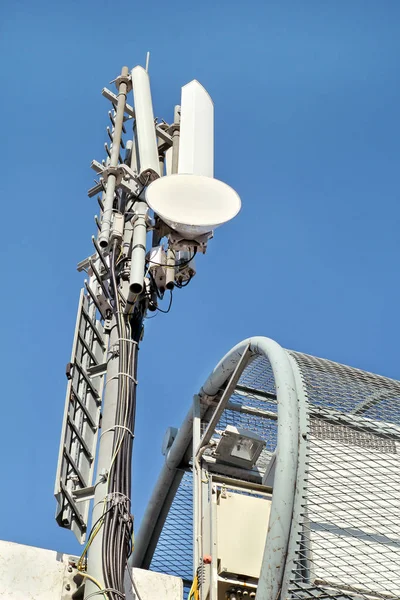 Telecommunication base stations network repeaters. The cellular communication aerial on a building. Communications cell phone telecommunication tower. Antenna tower and repeater. Modern technology.
