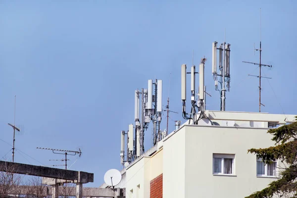 Telekomünikasyon baz istasyonları Tekrarlayıcı binanın çatısında ağ. Bir binanın çatı hava hücresel iletişim. Cep telefonu telekomünikasyon kulesi. Binanın üstüne antenler.