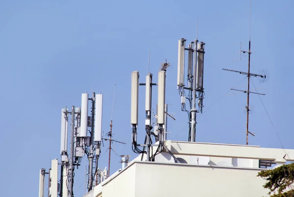 Telekomünikasyon baz istasyonları Tekrarlayıcı binanın çatısında ağ. Bir binanın çatı hava hücresel iletişim. Cep telefonu telekomünikasyon kulesi. Binanın üstüne antenler.