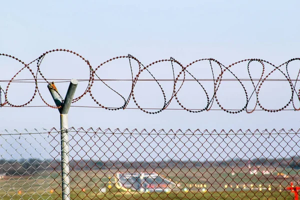 Security Fence. Protective wire barbed fence at the airport. A mesh barbed wire fence and concrete pillars, airport fence, fence around restricted area.