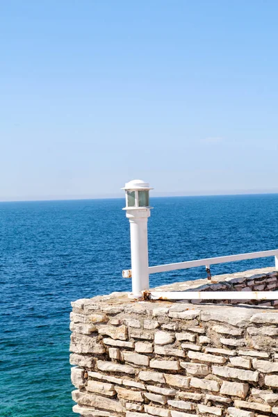 Arka plan mavi deniz kenarında beyaz fener taş duvar. Seyahat, yüzme, doğal peyzaj, yaz, Akdeniz, Adriyatik Denizi. — Stok fotoğraf