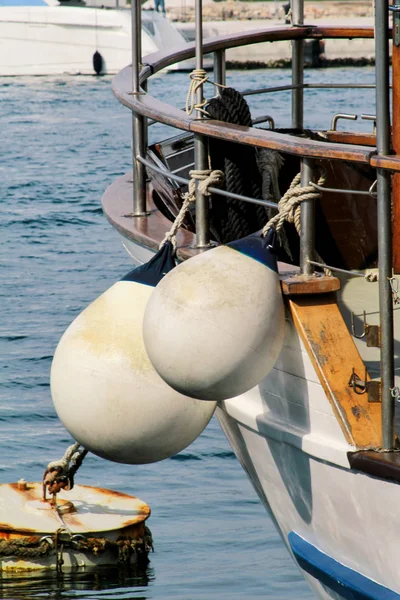Bóias e cordas de ancoragem, de perto. Bóias brancas em barco de pesca ancorado no porto. Bóias de amarração, doca e pára-lamas para proteção de barcos . — Fotografia de Stock