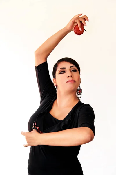 Joven gitana española bailando flamenco con castañuelas marrones en las manos. Bailarina flamenca de precioso vestido nacional sobre fondo blanco. Bailarina española en ropa tradicional. Ballet . — Foto de Stock