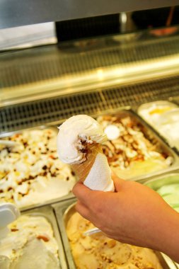 El tutar köşedeki dondurma. Dondurma waffle koni. Buzdolabı dondurma içinde belgili tanımlık geçmiş. Kadın dondurma dükkanında çalışıyor. Bir pastane. Vanilya, çikolata, meyve. Dükkanı tatlılar.