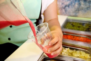 El meyve yüzlü cam içine. Taze yapılmış meyve yüzlü plastik kap içinde saman ile servis. Sağlıklı gıda ve organik meyve. Çeşitli taze meyve ve sebze salata sağlıklı öğeleri.
