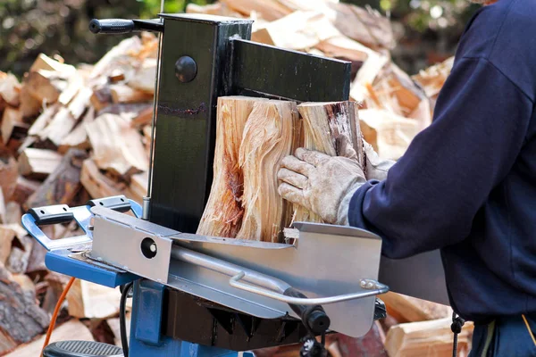 Zagen snijden hout voor de winter. Een man snijden brandhout voor de winter met behulp van een moderne machine-timmerhout zag. Houtindustrie. Stookseizoen, winterseizoen. Hernieuwbare bron van energie. Milieu concept. — Stockfoto