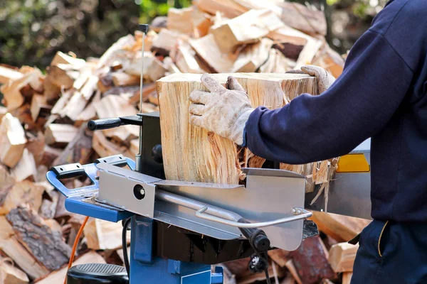 Såg högg ved för vintern. En man skära ved för vintern med en modern maskin virke såg. Träindustrin. Eldningssäsongen, vintersäsongen. Förnybar resurs av energi. Miljö koncept. — Stockfoto