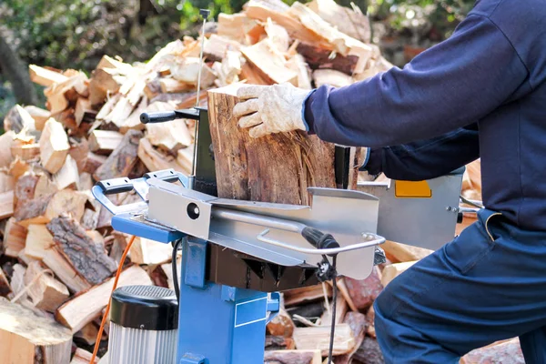 Såg högg ved för vintern. En man skära ved för vintern med en modern maskin virke såg. Träindustrin. Eldningssäsongen, vintersäsongen. Förnybar resurs av energi. Miljö koncept. — Stockfoto