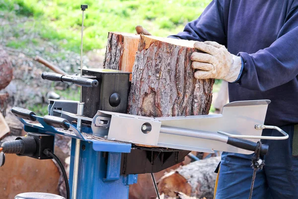 Zagen snijden hout voor de winter. Een man snijden brandhout voor de winter met behulp van een moderne machine-timmerhout zag. Houtindustrie. Stookseizoen, winterseizoen. Hernieuwbare bron van energie. Milieu concept. — Stockfoto