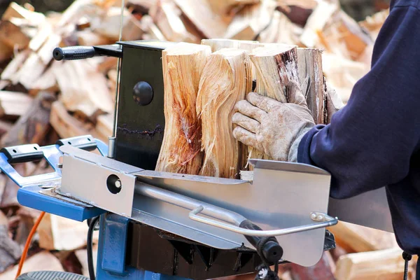 Såg högg ved för vintern. En man skära ved för vintern med en modern maskin virke såg. Träindustrin. Eldningssäsongen, vintersäsongen. Förnybar resurs av energi. Miljö koncept. — Stockfoto