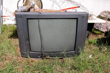 Eski bir Tv ile birlikte diğer hantal çöp bahçesinde vurulmuş ve sol ayarlayın. Eski bir Tv yanında bir duvar doğal ortamda karma çöp yığını ile atılır. Geri dönüşüm sanayi. Ekoloji değil. Ekoloji.