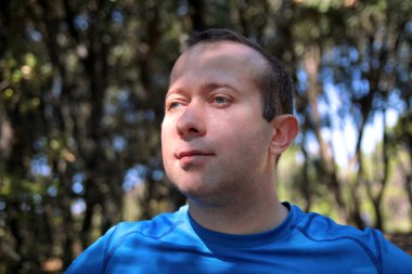 Spor giyim poz giyen kaslı yakışıklı genç, portre ve güzel manzara doğa açık güneşli bir günde keyfini çıkarın. Güzel adam, aktif, sporcu, çapraz uygun, sağlıklı yaşam, fitness kavramı.