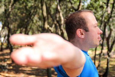 Yakışıklı kaslı genç adam ormandaki germe egzersizleri yapıyor. Sporcu spor giyim manzara doğada açık giyiyor. Güzel adam, etkin, çapraz uygun, sağlıklı yaşam, fitness insanlar kavramı.