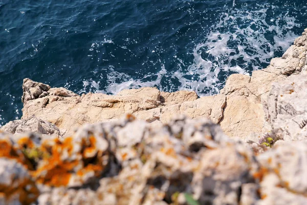 Rocks at seashore of Adriatic sea, Mediterranean, closeup. Aerial top view of sea waves hitting rocks on the beach.Stone, rocks, red algae and sea, shore and stones. Beautiful landscapes, seaside. — Stock Photo, Image