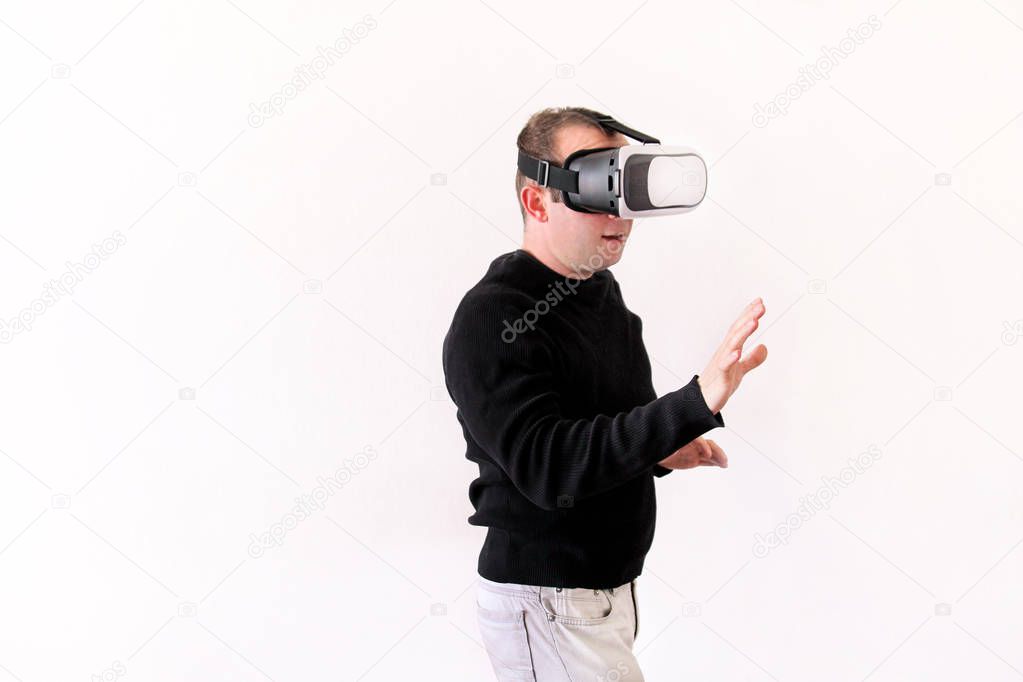 Man wearing and playing mobile game app on device virtual reality glasses on white background. Business man at office action and using in virtual headset box. Contemporary technology concept.