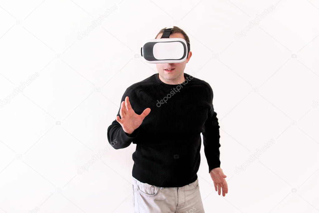 Man wearing and playing mobile game app on device virtual reality glasses on white background. Business man at office action and using in virtual headset box. Contemporary technology concept.