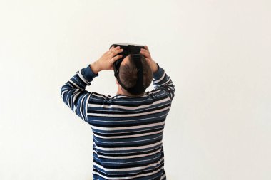 Giyen ve beyaz arka plan üzerinde aygıt sanal gerçeklik gözlükteki mobil oyun app oynamaya dostum. Adam eylem ve sanal kulaklık, Vr kutusunu kullanarak akıllı telefonla kullanabilir. Çağdaş teknoloji kavramı