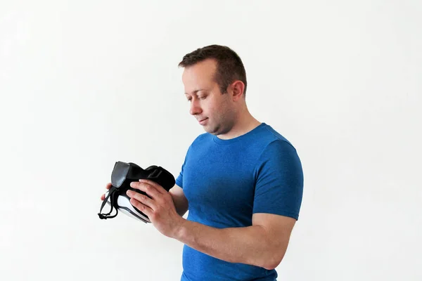 Uomo che indossa e gioca app di gioco mobile su occhiali di realtà virtuale del dispositivo su sfondo bianco. Azione uomo e utilizzo in cuffie virtuali, scatola VR per l'uso con smartphone. Concetto tecnologico contemporaneo — Foto Stock