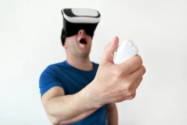 男子穿着和玩手机游戏应用程序在设备虚拟现实玻璃上的白色背景。男子行动和使用虚拟耳机, Vr 框, 用于智能手机。当代技术理念 — 图库照片
