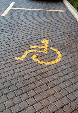 Post ile Park alanı ve Park araba parkında defne önünde iz devre dışı / Park özel ihtiyaçları olan insanlar için işaretlenmiş / Engelliler sembolü, asfalt, yol ve sokak detay boyalı işareti.