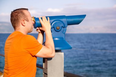 Turistik plaj üzerine teleskopu güzel doğal ortamda saatler / Panorama ve deniz ve gökyüzü görünümü / Man kullanarak seyahat ve Turizm teleskop, beach, Adriyatik Denizi, Mediterranean bakar.