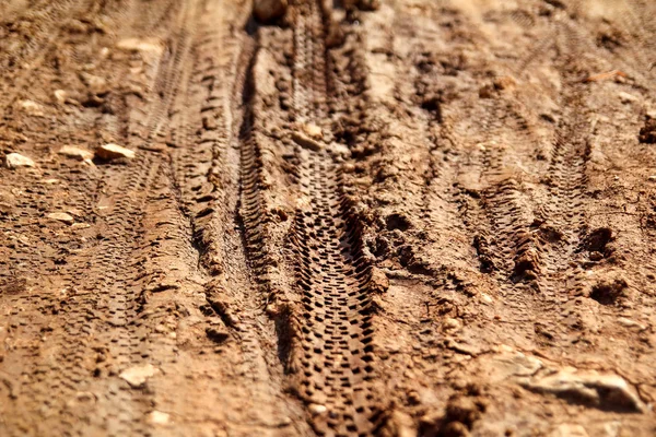 自行车轮胎轨道上泥泞的小道版税 轮胎在潮湿泥泞的道路上跟踪 抽象的背景 纹理材料 轮胎轨道上的泥土或泥 复古的色调 粗糙的色调 在沙滩上的驱动器 越野轨道 — 图库照片