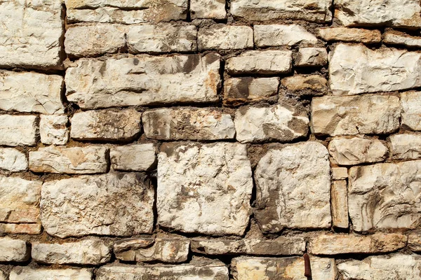 Part of natural contrast masonry wall stone granite is a pattern of texture, material and background with colored stones / Old brick wall as background wallpaper, close up / Stones were arranged.