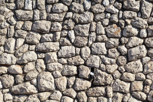 Natural contrast masonry wall stone granite is a pattern of texture, material and background with colored stones / Old brick wall as background wallpaper, close up / Decorative stones were arranged.