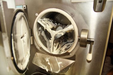 Dondurma fabrika Ice cream maker Makina gelen dondurma pisliği temizliyor. Dondurma hazırlanması.