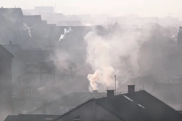 Evlerin çatıları. Bacalar sigara / sis ve duman üzerinde çatı üstleri City / kış sabah sis güzel görünümü doldurma ufuk peyzaj Belgrad, Sırbistan için evlerin üzerinde. / Ekoloji. Değil ekoloji.
