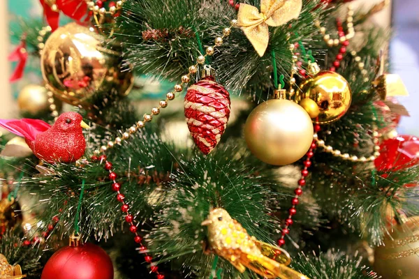 Noworoczne kolorowe ozdoby dekoracyjne na choince. Pokój urządzony do obchodów Bożego Narodzenia, scena wakacyjna o różnych kształtach, wielokolorowe kulki, dekoracyjne kokardki blask i ptak na drzewie. — Zdjęcie stockowe
