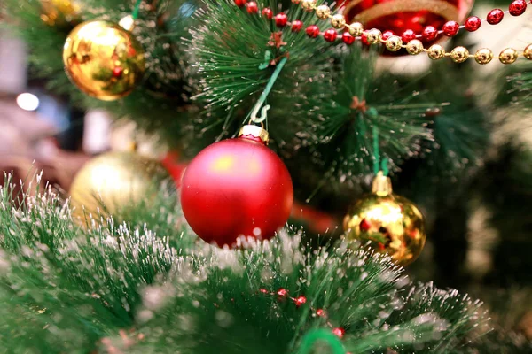 Decoração colorida de Ano Novo ornamentos na árvore de Natal. Quarto decorado para celebração de Natal, cena de férias com várias formas, bolas multicoloridas, arcos brilhantes decorativos e pássaro na árvore . — Fotografia de Stock