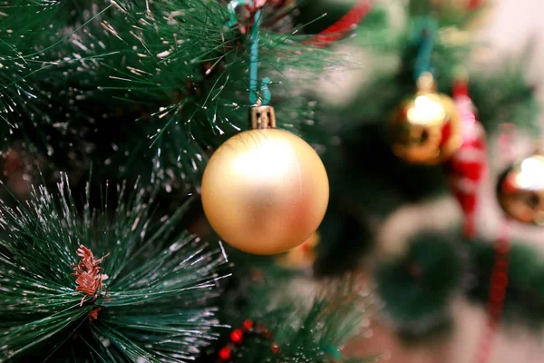 Decoração colorida de Ano Novo ornamentos na árvore de Natal. Quarto decorado para celebração de Natal, cena de férias com várias formas, bolas multicoloridas, arcos brilhantes decorativos e pássaro na árvore . — Fotografia de Stock