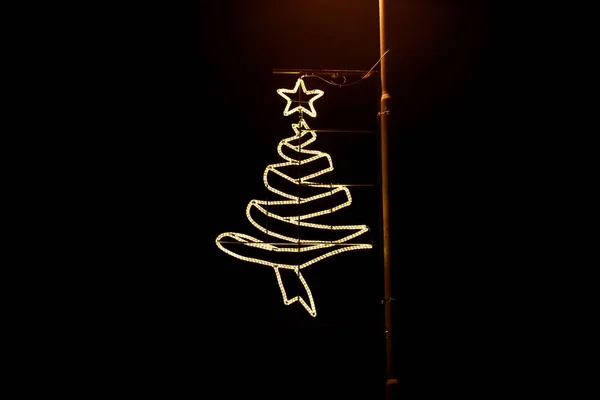 Street New Year e decorazioni natalizie, lampadine luci di riso stringa. Luci lampeggianti decorative, ornamenti a forma di albero e stella in cima alla celebrazione di Natale, scena di festa. Concetto Natale . — Foto Stock