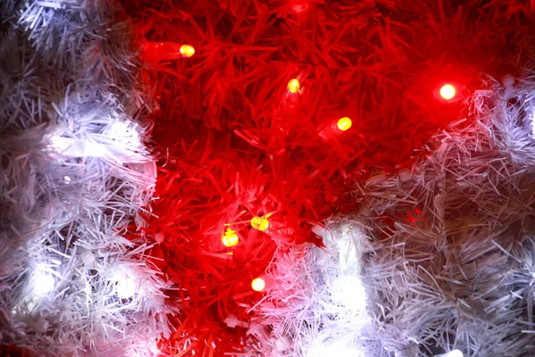 Part of Christmas decorative red and white flashing lights, close up. Street detail of New Year and Christmas decorations, string rice lights bulbs. Ornaments to christmas celebration, holiday scene. — Stock Photo, Image