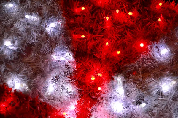クリスマスの装飾的な赤と白の点滅するライトの一部を閉じます。新年やクリスマスの装飾の通りの詳細は、文字列の電球。クリスマスのお祝い、休日のシーンへの装飾. — ストック写真