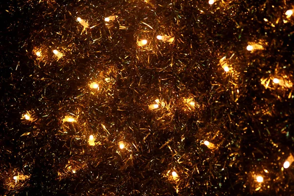 Part of Christmas decorative yellow and white flashing lights, close up. Detail of New Year and Christmas decorations, string rice lights bulbs. Ornaments to christmas celebration, holiday scene.