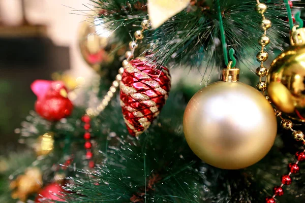 Decorazioni colorate di Capodanno sull'albero di Natale. Camera decorata per la celebrazione del Natale, scena di festa con varie forme, palline multicolori, fiocchi decorativi scintillanti e uccello sull'albero . — Foto Stock