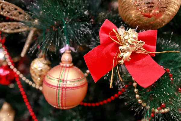 Újévi színes dísztárgyak karácsonyfa. Szoba díszített karácsonyi ünnepség, ünnep jelenet különböző formájú, sokszínű golyók, dekoratív szikrázó íjak és madár a fán. — Stock Fotó