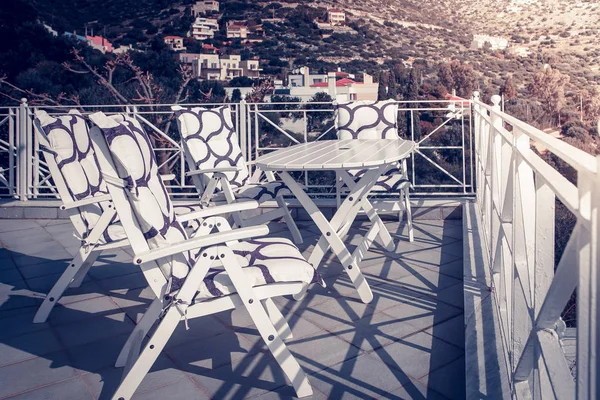 Deniz kenarında, Yunanistan terasta bir tabloyla sandalye