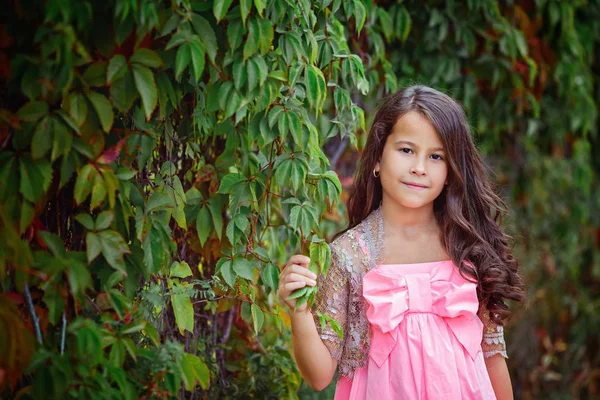 Hosszú, áramló haj, zöld parkban egy mosolygós kislány portréja. Nyári fotó, közelről. — Stock Fotó